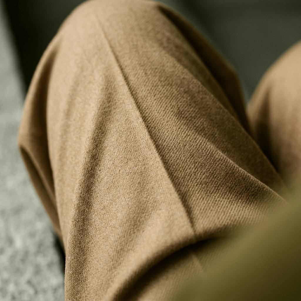Close detail of the trouser fabric falling over the knee, showing the weave and the drape