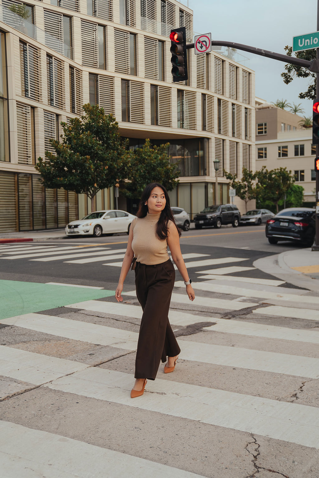 Petite dress pants in Espresso, a deep warm brown, crossing the street on a workday commute in Pasadena, The Petite Standard