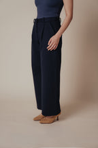 Petite dress pants in Midnight, a deep navy blue, side view showing the high rise and wide straight leg, The Petite Standard