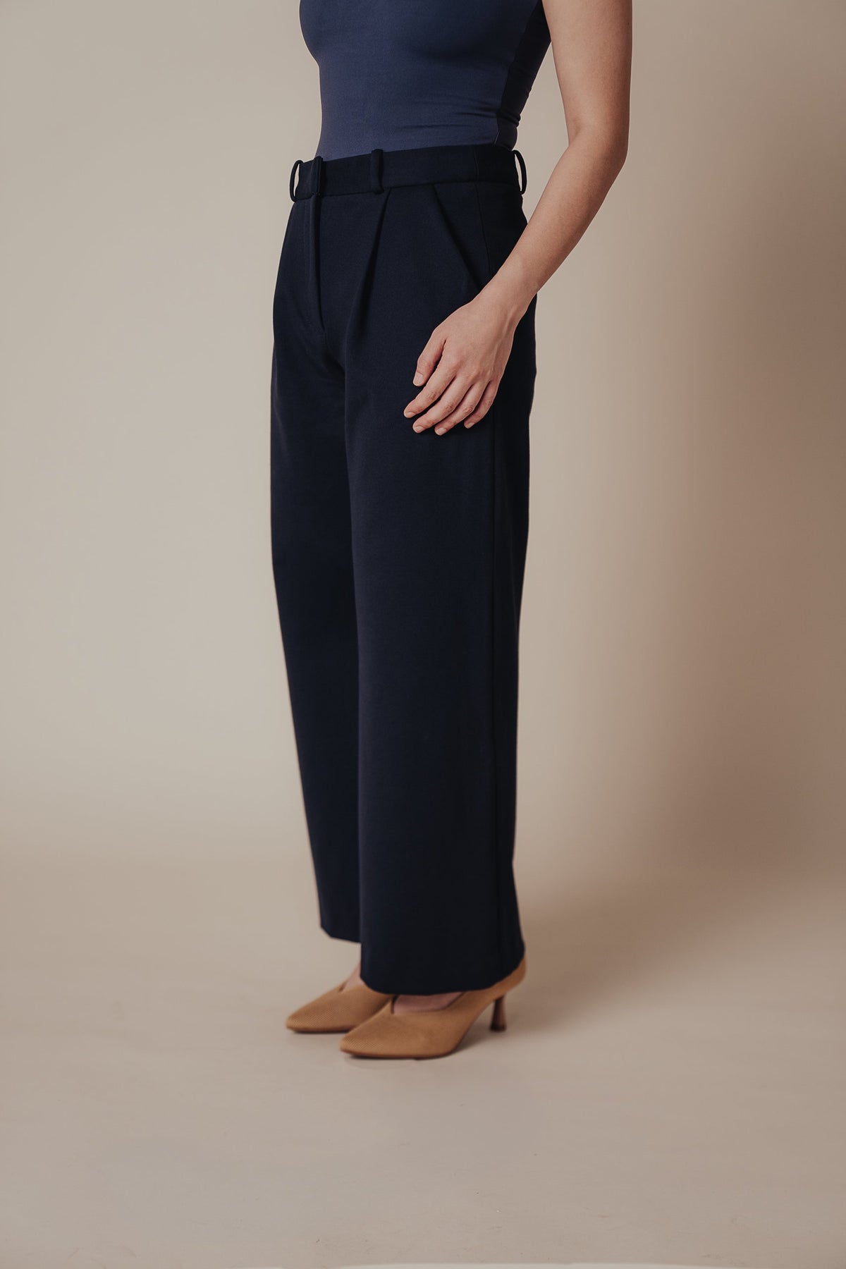 Petite dress pants in Midnight, a deep navy blue, side view showing the high rise and wide straight leg, The Petite Standard