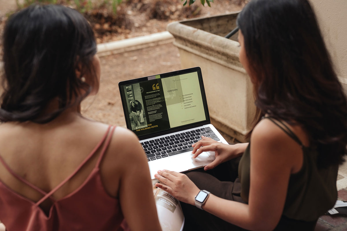 The Petite Standard founders reviewing the website on a laptop